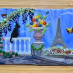 Glass scene of Eiffel Tower, black cat sitting on fence, and pot with flowers by artist Jennifer Campagna
