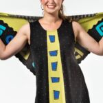 Woman wearing a black with yellow designed top and scarf by artist Sondra Sardis