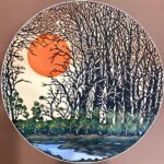 Round paper cut landscape with trees, creek, and sun by artist Jupi Das