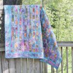 Colorful woven blanket hanging on fence outside